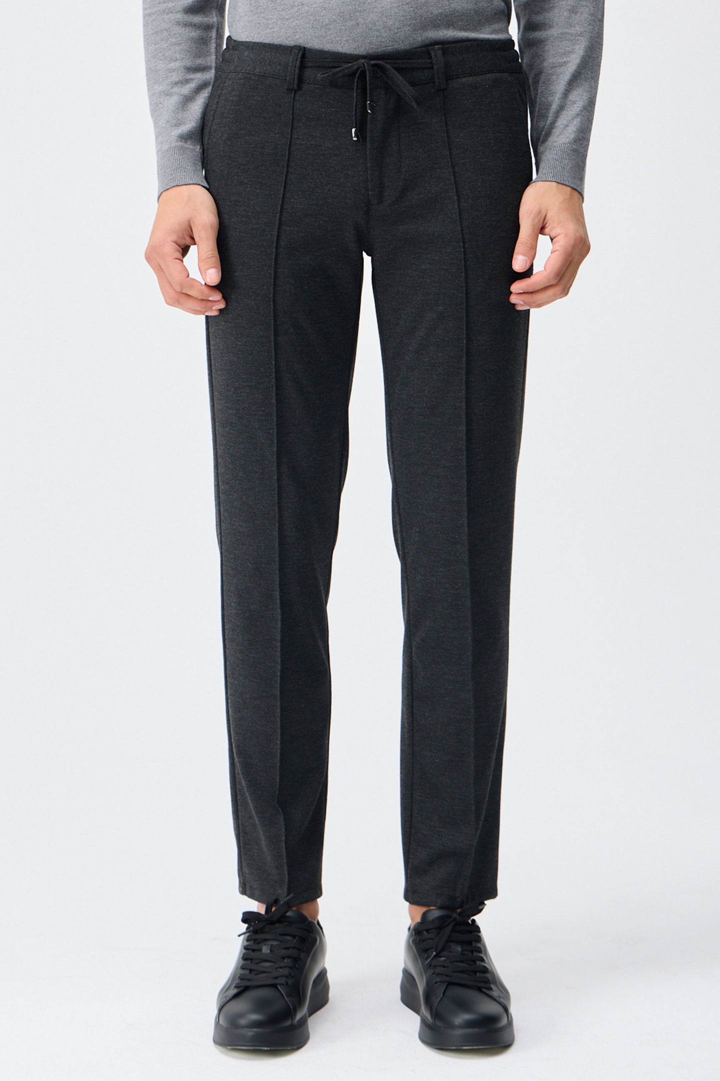 Herenpantalon met trekkoord in taupe- en antracietkleur, getailleerde pasvorm en taps toelopende pijpen.