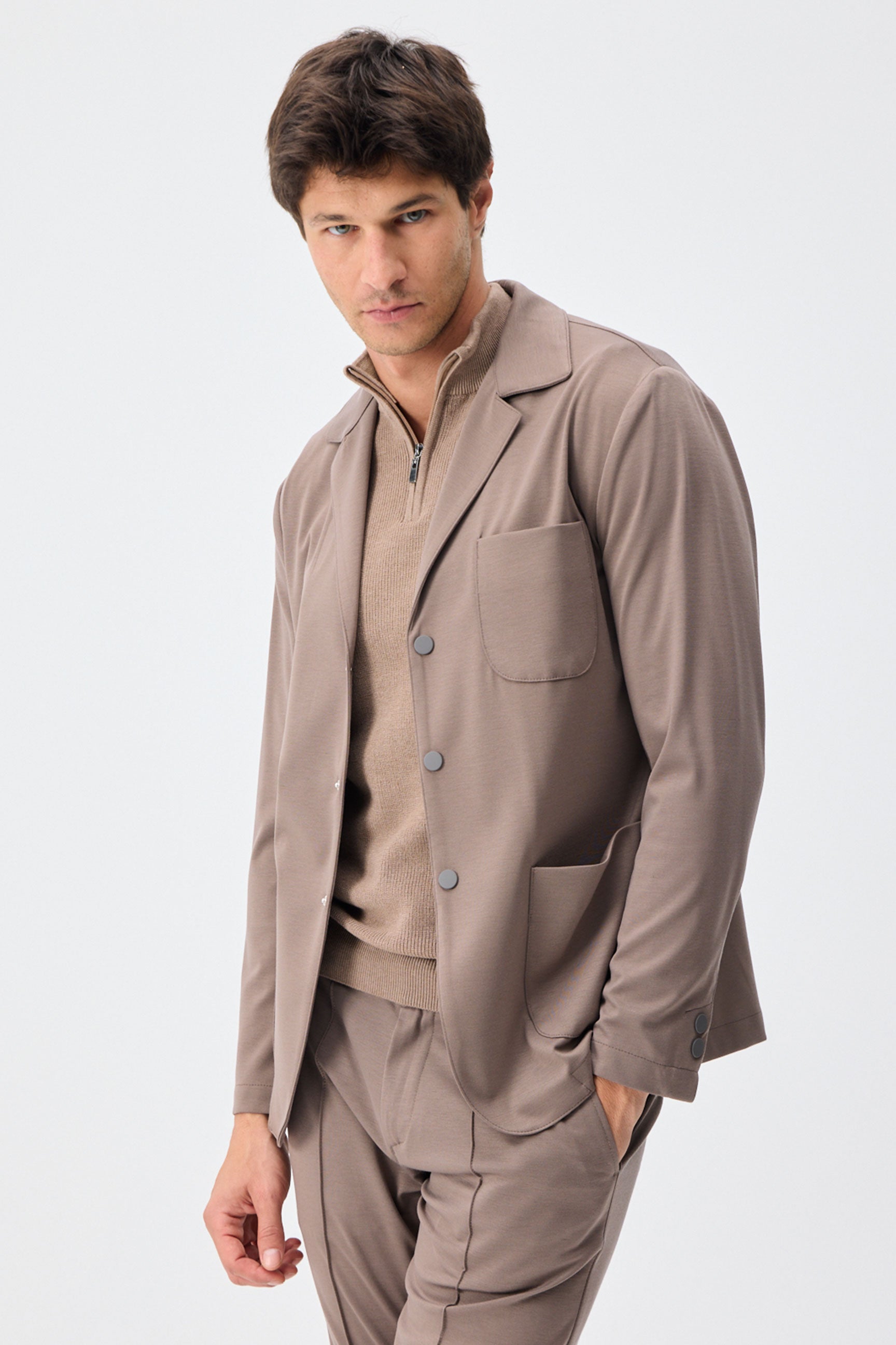 Herenpak bestaande uit een blazer en een broek van zachte, bruine jersey in smart casual stijl.