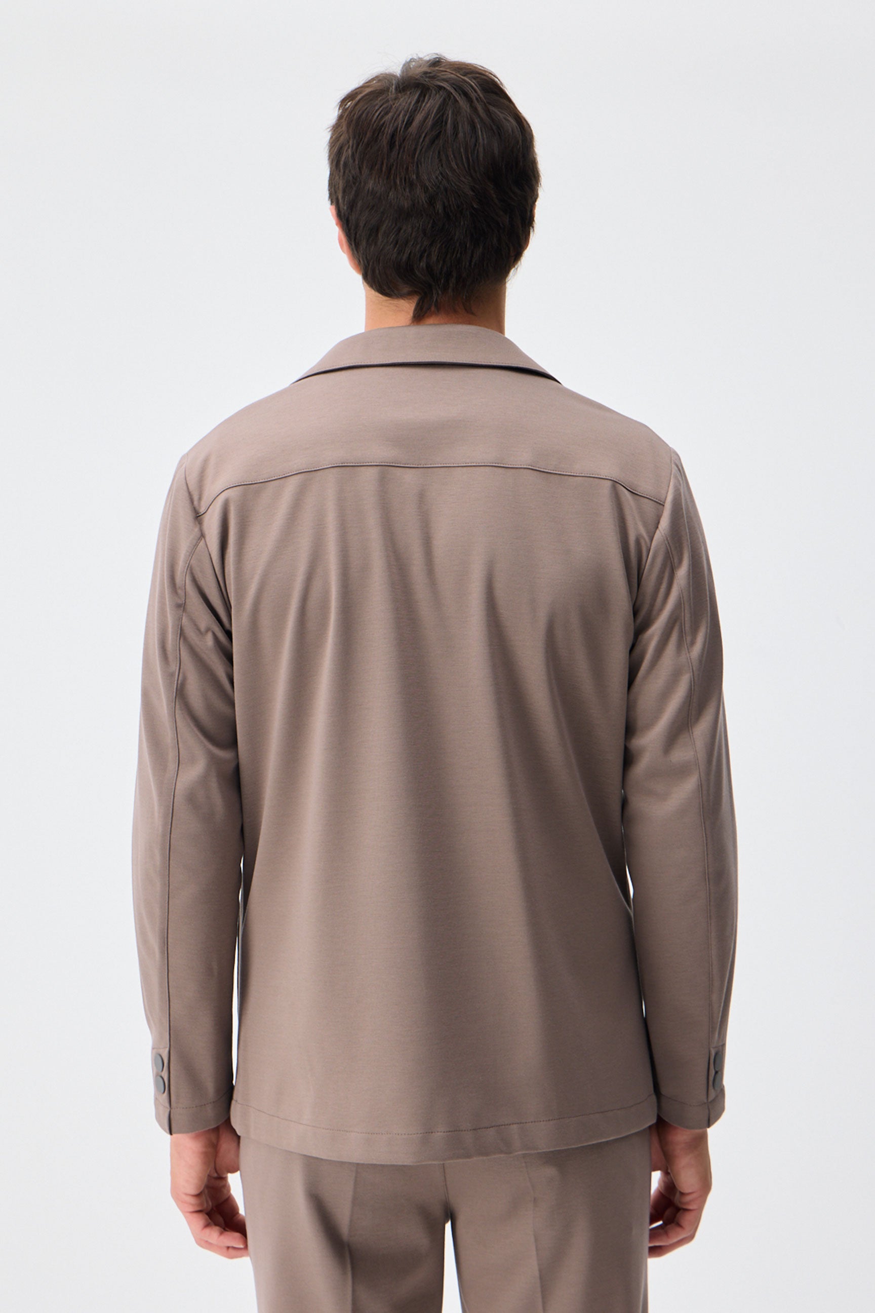 Herenpak bestaande uit een blazer en een broek van zachte, bruine jersey in smart casual stijl.