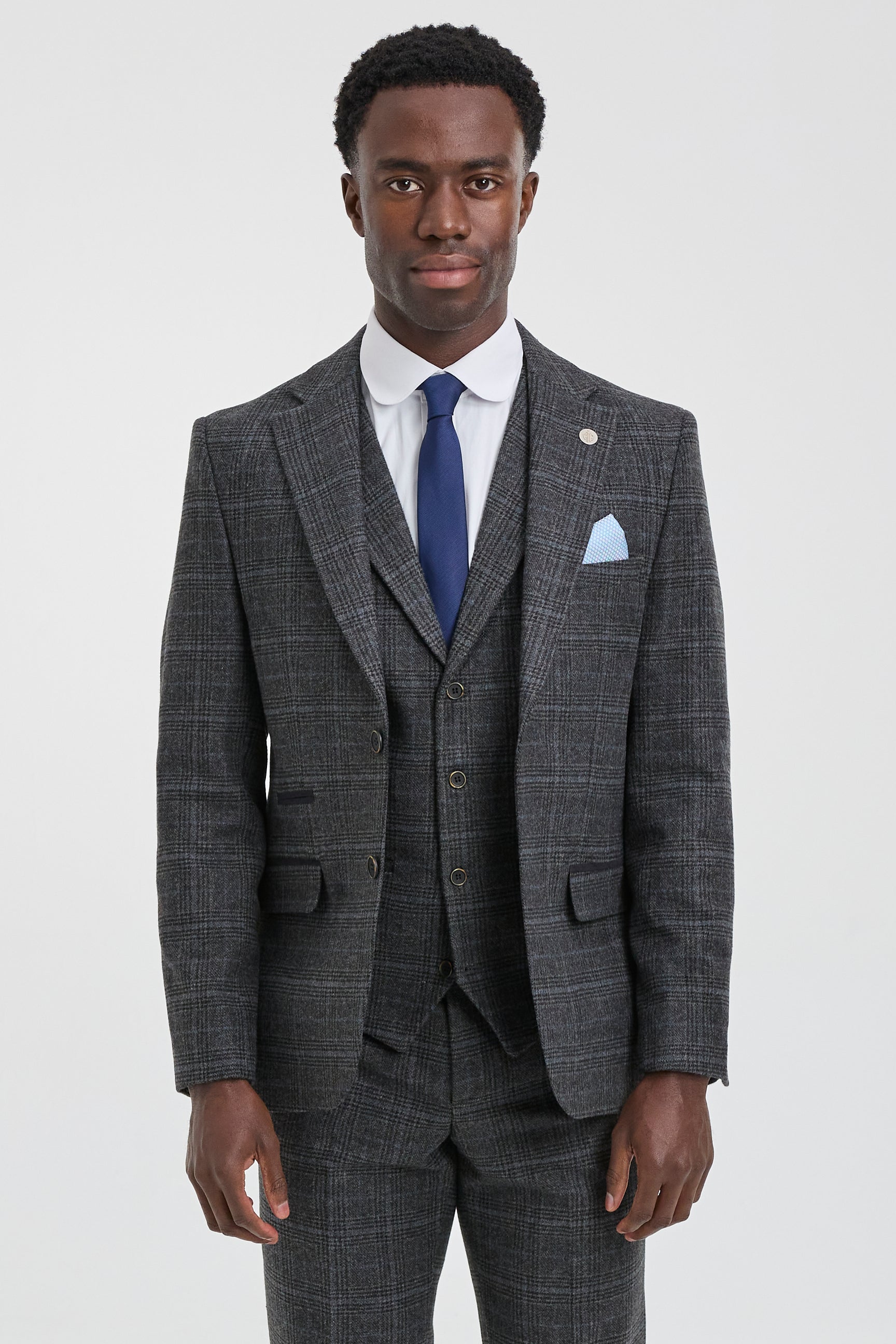 Man wearing a gray checkered suit with a blue tie and pocket square on a white background