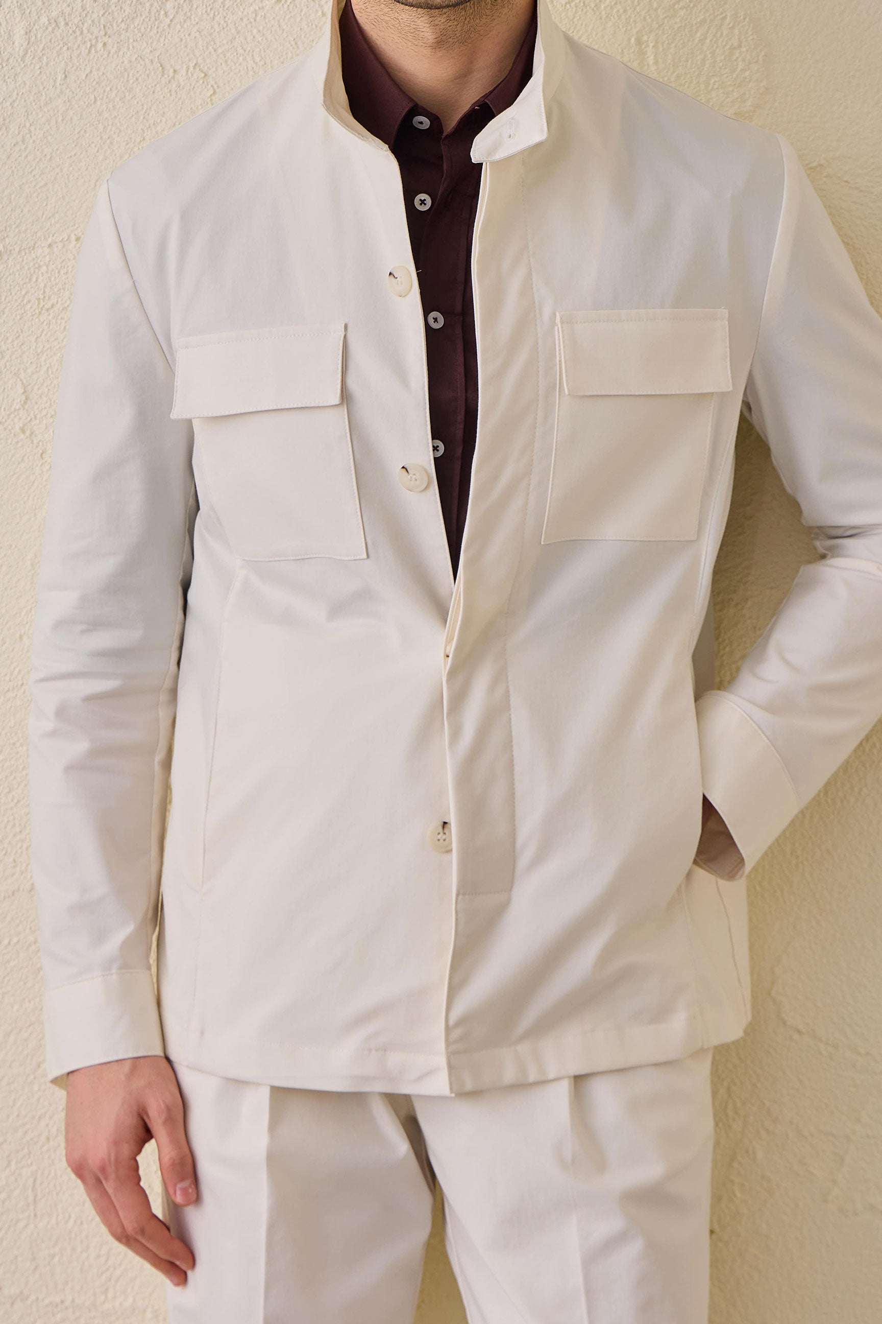Wit smart casual tweedelig pak voor heren in safaristijl met opstaande kraag en stretchstof.