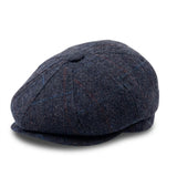 Herenpet in marineblauwe wollen tweedstof, model newsboy.