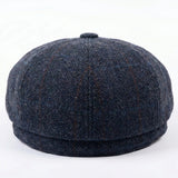 Herenpet in marineblauwe wollen tweedstof, model newsboy.